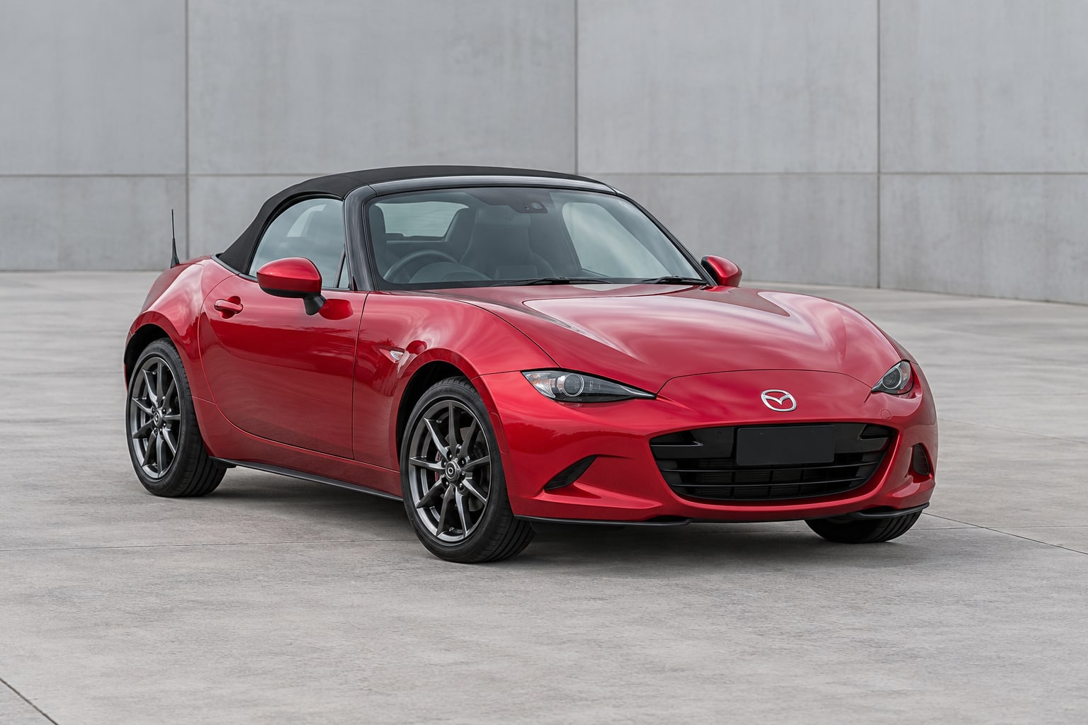 Red Mazda MX-5 roadster parked in an industrial courtyard